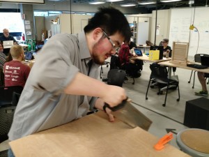 Derek cutting the board with a handsaw